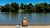A man cools off by the river in Sacramento, Calif., July 2, 2024. Parts of California sweltered Tuesday, and things are expected to get worse during the Fourth of July holiday week for parts of the U.S. with nearly 90 million people under heat alerts.