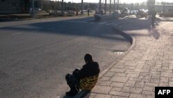 An asylum-seeker sits near the Nuijamaa border crossing between Finland and Russia, in Lappeenranta, Nov. 17, 2023, after the Finnish government said it would close four of eight eastern crossings with Russia the next day. One crossing now remains open.