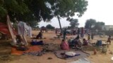 FILE - Residents displaced from a surge of violent attacks squat on blankets and in hastily made tents in the village of Masteri in west Darfur, Sudan, July 30, 2020. 