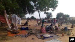 FILE - Residents displaced from a surge of violent attacks squat on blankets and in hastily made tents in the village of Masteri in west Darfur, Sudan, July 30, 2020. 