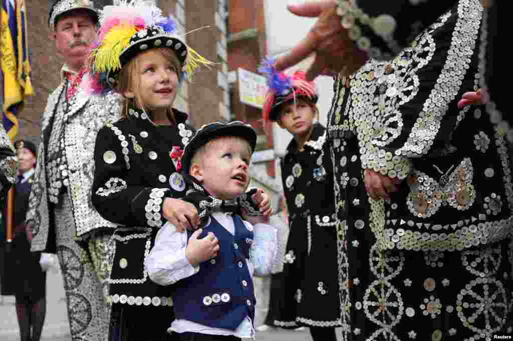 Pearly Prince of Harrow Harrison Ferrari, 3, and Pearly Princesses of Harrow Ariana Ferrari, 7, and Esme Ferrari, 9, participate in the Harvest Festival service at the Guildhall, in London.