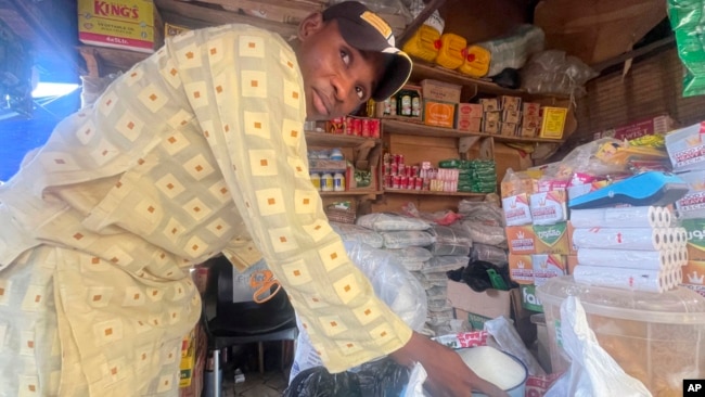 FILE - Abba Usman sells granulated sugar at his shop inside a market in Abuja, Nigeria, Oct. 27, 2023.