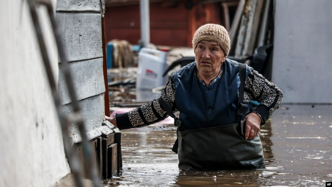 A woman walks near her house in a flooded area in Orenburg, Russia, Wednesday, April 10, 2024. (AP Photo)