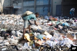People cull through a garbage pile looking for salvageable items in Port-au-Prince, Haiti, April 6, 2024.