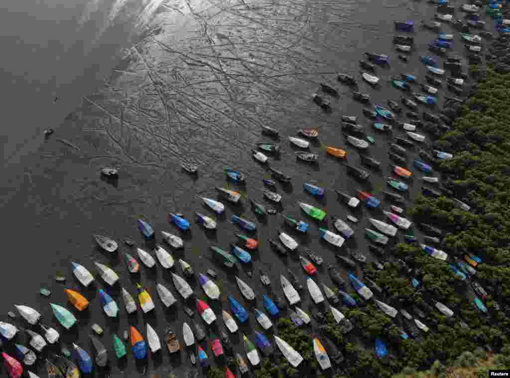 An aerial view of fishing boats covered with tarpaulin sheets parked on the shore, before the start of the monsoon season, on the outskirts of Mumbai, India.