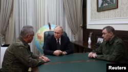 Rais wa Russia Vladimir Putin akizungumza na Waziri wa Ulinzi Sergei Shoigu na Mkuu wa Majenerali Valery Gerasimov huko Rostov-on-Don, Russia. Picha na REUTERS 