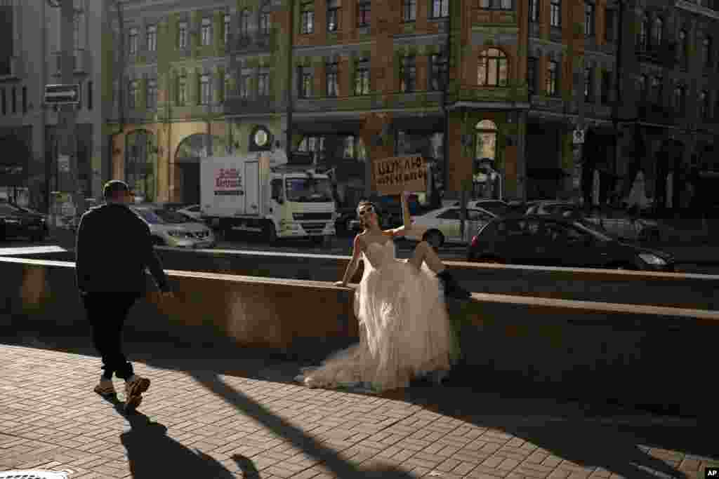 Una mujer posa para una campaña en redes sociales en Kiev, Ucrania, el 31 de octubre de 2023. El cartel dice &quot;Buscando un novio&quot;. (AP Foto/Bram Janssen).