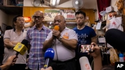 "The Bull," Tsang Kin-shing, center, founder of Hong Kong's pro-democracy Citizens' Radio station, along with station guests, speaks to reporters prior to the station's last broadcast in Hong Kong, June 30, 2023.