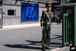FILE - An officer stands guard at the entrance to the European Union delegation's compound in Beijing, Oct. 14, 2023. Chinese leaders will gather in July 2024 for a meeting that will likely reveal details of China's attempts to boost its economy.