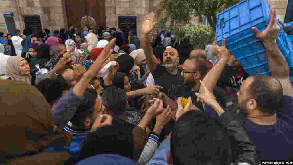 With Al-Azhar Mosque’s charity iftar at capacity, hundreds gather outside for free juice and dates to break their 14-hour fast, Cairo. (Hamada Elrasam/VOA) 