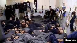 FILE - Foreign prisoners, suspected of being part of the Islamic State group, lie in a prison cell in Hasaka, Syria, Jan. 7, 2020.