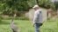 FILE - The white-naped crane Walnut and her keeper Chris Crowe walk in the grounds of her habitat at the Smithsonian's National Zoo in 2021. 