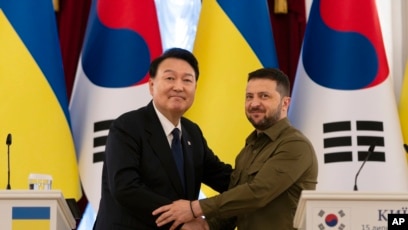 South Korean President Yoon Suk Yeol, left, and Ukrainian President Volodymyr Zelenskyy stand for photos after delivering statements, July 15, 2023, in Kyiv, Ukraine.