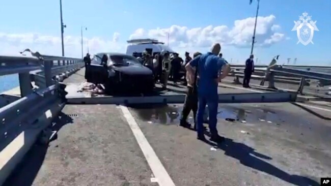 Investigators work on the automobile span of the Crimean Bridge connecting Russian mainland with Crimea after traffic on the bridge was halted July 17, 2023, after reports of explosions. (Investigative Committee of Russia via AP)