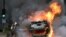 A firefighter extinguishes a burning car at the end of a commemoration march for a teenage driver shot dead by a policeman, in the Parisian suburb of Nanterre, France, June 29, 2023.