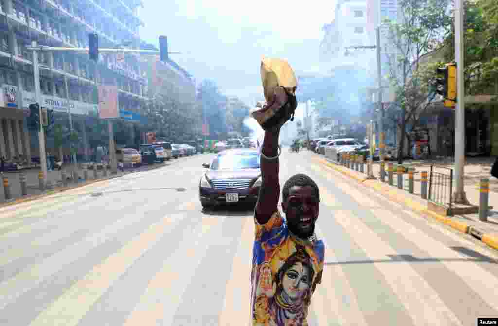 An activist reacts after riot police officers threw teargas containers to break up the crowd of protesters, during a march to call on lawmakers to reject the finance bill proposed by the government that would raise taxes, along Harambee avenue in downtown Nairobi, Kenya.&nbsp;