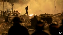 A demonstrator runs on the third night of protests sparked by the fatal police shooting of a 17-year-old driver in the Paris suburb of Nanterre, France, June 30, 2023.