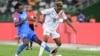 Le milieu de terrain #8 Samuel Moutoussamy (G) de la RD Congo se bat pour le ballon avec l'attaquant #19 François Kamano de la Guinée pendant le match de quart de finale de la Coupe d'Afrique des Nations (CAN) 2024 , Abidjan, le 2 février 2024. (Photo SIA KAMBOU / AFP)