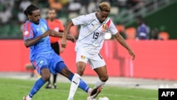 Le milieu de terrain #8 Samuel Moutoussamy (G) de la RD Congo se bat pour le ballon avec l'attaquant #19 François Kamano de la Guinée pendant le match de quart de finale de la Coupe d'Afrique des Nations (CAN) 2024 , Abidjan, le 2 février 2024. (Photo SIA KAMBOU / AFP)