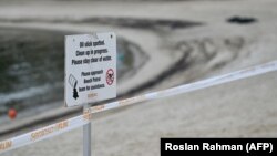 Pantai Siloso di Pulau Sentosa di Singapura ditutup karena tumpahan minyak di pelabuhan terdekat. (Foto: Roslan Rahman/AFP)