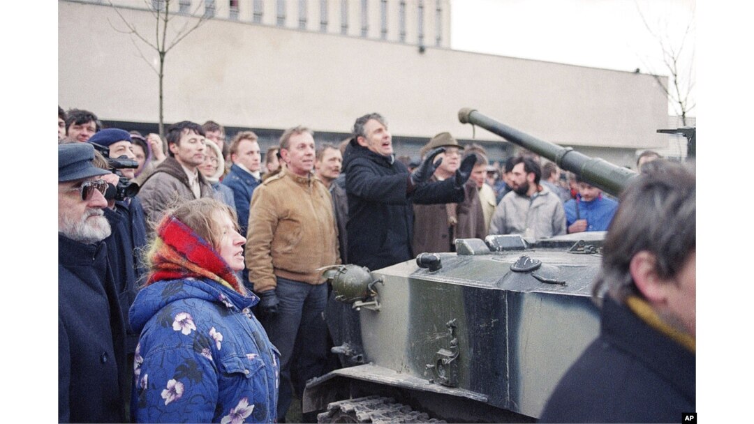 FILE - Lithuanians stand in front of a Red Army armored vehicle as soldiers arrive to take over the main printing house in the center of Vilnius, Jan. 11, 1991.