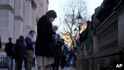 A woman prays on the route as she takes part in a pro-Palestinian demonstration as they wend their way along Whitehall in London, Nov. 25, 2023.