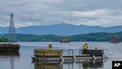 Larry Gaylord, DJ Dorbert and Chad Frederick return on a barge after building scaffolding at the Hudson-Athens Lighthouse, June 12, 2024, in Hudson, New York.