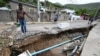 Warga setempat memeriksa saluran air yang rusak di Shooters Hill, Jamaika, setelah Badai Beryl melanda kawasan itu, Kamis 4 Juli 2024.
