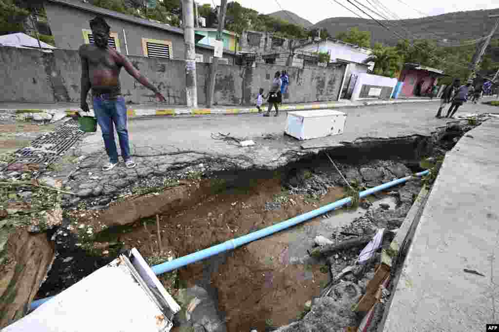 Residents look at a damaged drain in Shooters Hill, Jamaica, in the aftermath of Hurricane Beryl.&nbsp;Beryl powered towards Mexico and the Cayman Islands, threatening strong winds and a storm surge after battering Jamaica&#39;s southern coast.