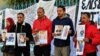 Des familles de personnes originaires d'al-Hansha, disparues en mer lors de tentatives de migration, brandissent des portraits appelant le gouvernement à soutenir les efforts visant à découvrir ce qui est arrivé à leurs proches, Tunis le 6 février 2024. (Photo FETHI BELAID/AFP)