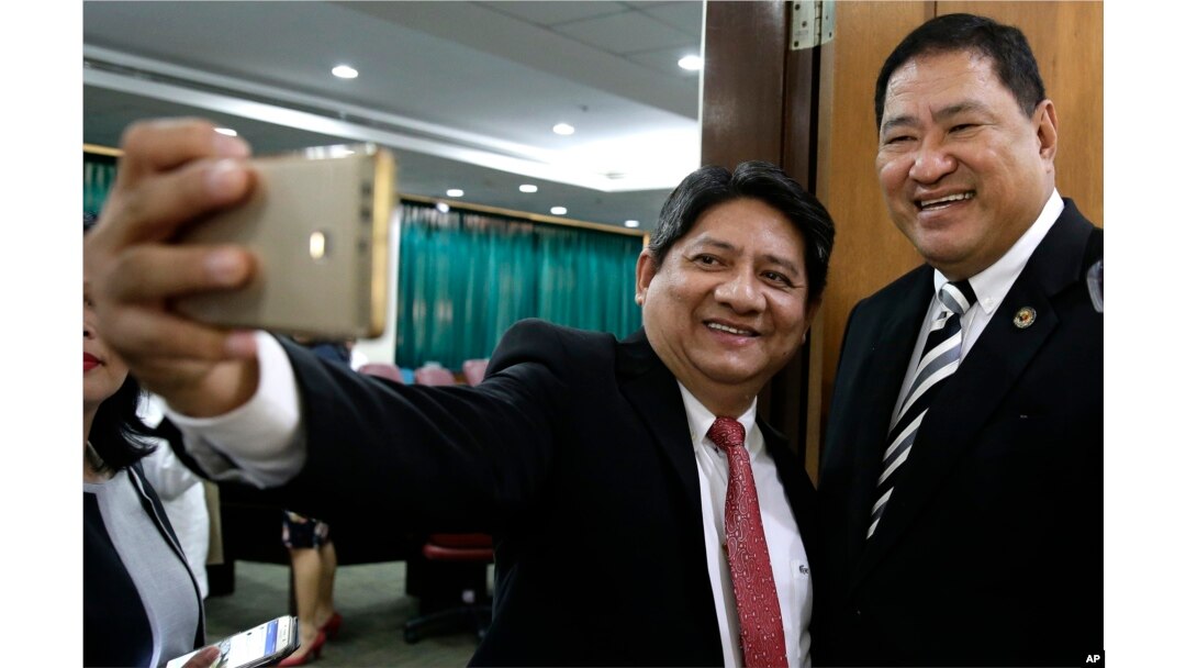 Pengacara Larry Gadon (kiri), berswafoto dengan Ketua Komite Kehakiman DPR, Reynaldo Umali, setelah sidang Komisi Keadilan DPR di metropolitan Manila, Filipina, Senin, 19 Maret 2018. (AP/Aaron Favila)