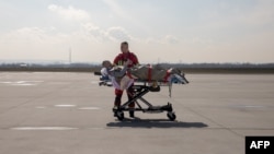 Ukrainian medical personnel transport a wounded soldier to a medical evacuation (Medevac) airplane, in Rzeszow, Poland on March 22, 2023.