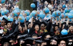 FILE -- Graduates of Harvard's John F. Kennedy School of Government celebrate during Harvard University's commencement exercises in Cambridge, Mass., May 30, 2019.