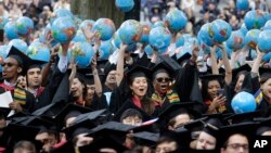 资料照片：2019年5月30日，哈佛大学肯尼迪政府学院的毕业生在毕业典礼上欢庆。（美联社照片）