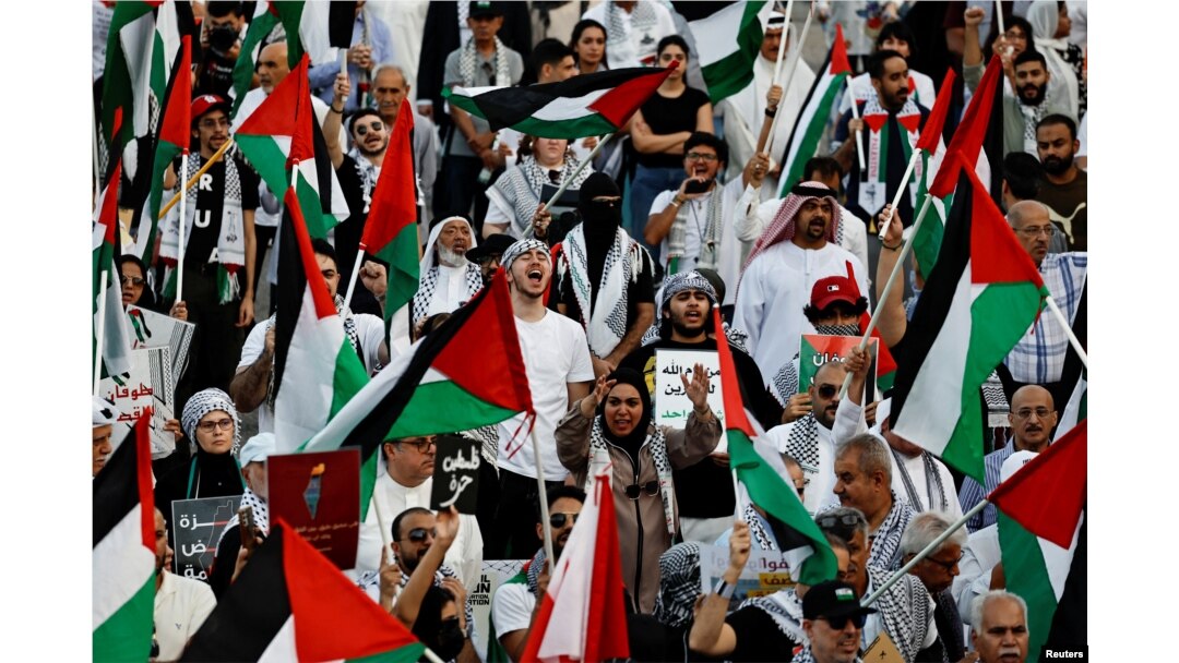 بحرین میں ہونے والے احتجاج میں لوگوں نے فلسطینی پرچم تھامے ہوئے ہیں۔