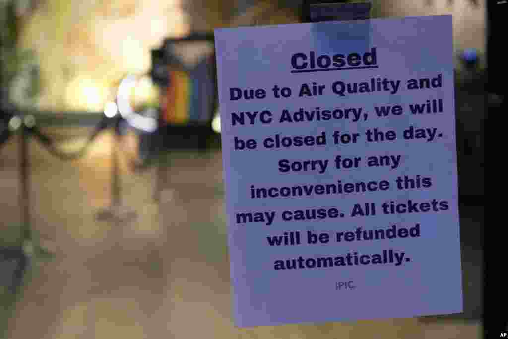 A sign is displayed on the door of an IPIC theater explaining that it is closed due to air quality in New York, June 7, 2023.