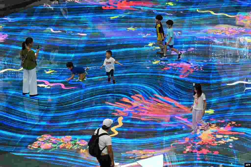 Children play with an interactive projection on the floor at the Marina Bay Sands mall in Singapore.