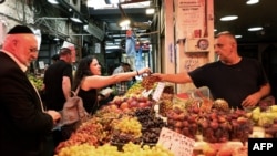 FILE - People shop for produce at a market in Jerusalem, Sept. 30, 2022. One such market recently offered the first shipment from Pakistan of food products offloaded in Israel.