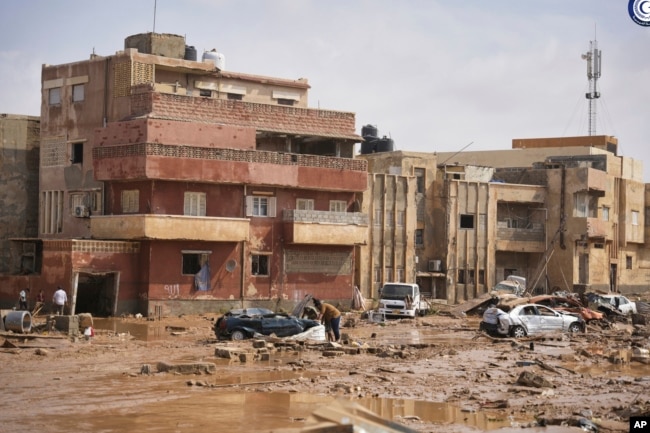 In this photo provided by the Libyan government, cars and rubble sit in a street in Derna, Libya, on Monday, Sept. 11, 2023, after it was flooded by heavy rains. (Libyan government via AP)