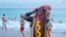Christina Lusk of Fort Lauderdale adjusts her wet hotdog costume as she emerges from the ocean in Hollywood, Florida.