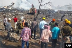 Petugas penyelamat dan penduduk setempat berkumpul di dekat pabrik petasan menyusul ledakan di distrik Harda di negara bagian Madhya Pradesh, India, 6 Februari 2024. Sedikitnya delapan orang dilaporkan tewas dan 80 lainnya luka-luka dalam insiden ini. (AFP)