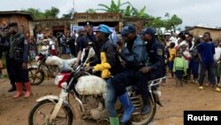 FILE - Congolese police officers secure the streets during a campaign rally of presidential candidate Moise Katumbi in Kitutu village within Mwenga territory of South Kivu province, Democratic Republic of the Congo, Nov. 24, 2023. 