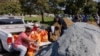 Warga mengisi karung dengan pasir di sebuah taman di San Diego, California, sebagai persiapan menghadapi hujan lebat dan kemungkinan banjir pada 31 Januari 2024. (Foto: Reuters/Mike Blake)