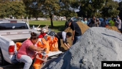 Warga mengisi karung dengan pasir di sebuah taman di San Diego, California, sebagai persiapan menghadapi hujan lebat dan kemungkinan banjir pada 31 Januari 2024. (Foto: Reuters/Mike Blake)