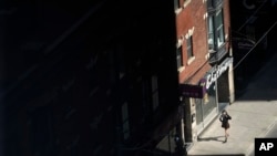 FILE - A masked pedestrian walks through downtown Toronto, Canada, Sept. 10, 2021. 