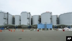 A black pipeline runs along tanks containing treated radioactive wastewater at the Fukushima Daiichi nuclear power plant in Futaba town, Japan, July 14, 2023. 