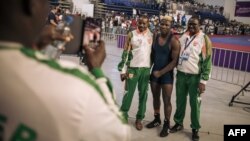 Niger delegation members pose with one of their wrestlers, center, who won a bout at the 9th Francophone Games in Kinshasa, July 30, 2023. Because of the July 26 military coup in Niamey, some members of the Niger delegation were unable to reach Kinshasa.