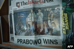 Halaman depan surat kabar berbahasa Inggris "Jakarta Post" menampilkan paslon 02 Prabowo Subianto (kiri) dan Gibran Rakabuming Raka, sehari setelah pemilihan presiden dan legislatif di Jakarta, 15 Februari 2024. (Yasuyoshi CHIBA / AFP)
