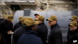 Sailors gather for a work party on the USS Bataan at Norfolk Naval Station in Norfolk, Virgina, March 20, 2023. Sailor work shifts easily can be 12 hours or longer on a given day.