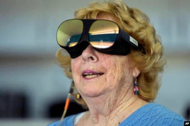 Karen Audet, an 82-year-old retired elementary school teacher, wears a Mynd Immersive virtual reality headset at John Knox Village, Wednesday, Jan. 31, 2024, in Pompano Beach, Fla. (AP Photo/Lynne Sladky)